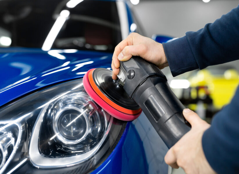 Professional detailing a car in car studio, hands with orbital polisher, scratching remover, vehicle care concept
